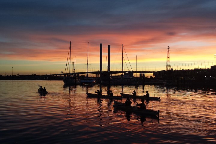 Kayaks on the Yarra River at sunset with Melbourne's skyline