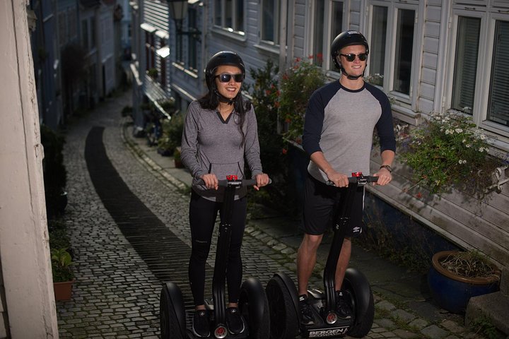 Gruppe auf Segways in den Anhöhen von Bergen mit Panoramablick über die Stadt