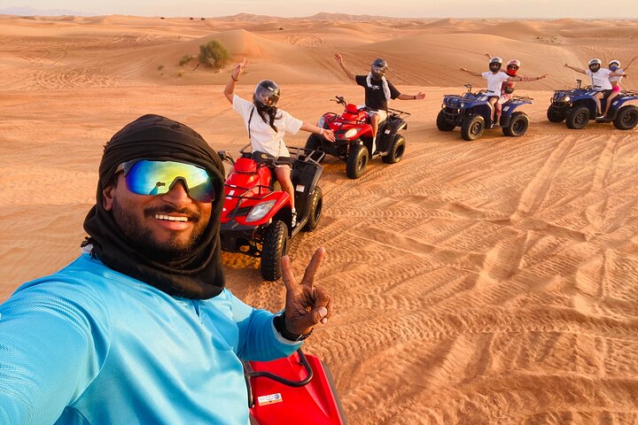 Quad bikes and camels at sunset in the Lahbab desert near Dubai