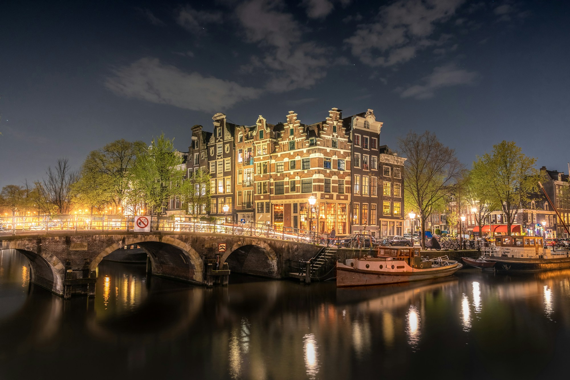 Brücke über eine Gracht in Amsterdam, mit Spiegelungen im Wasser