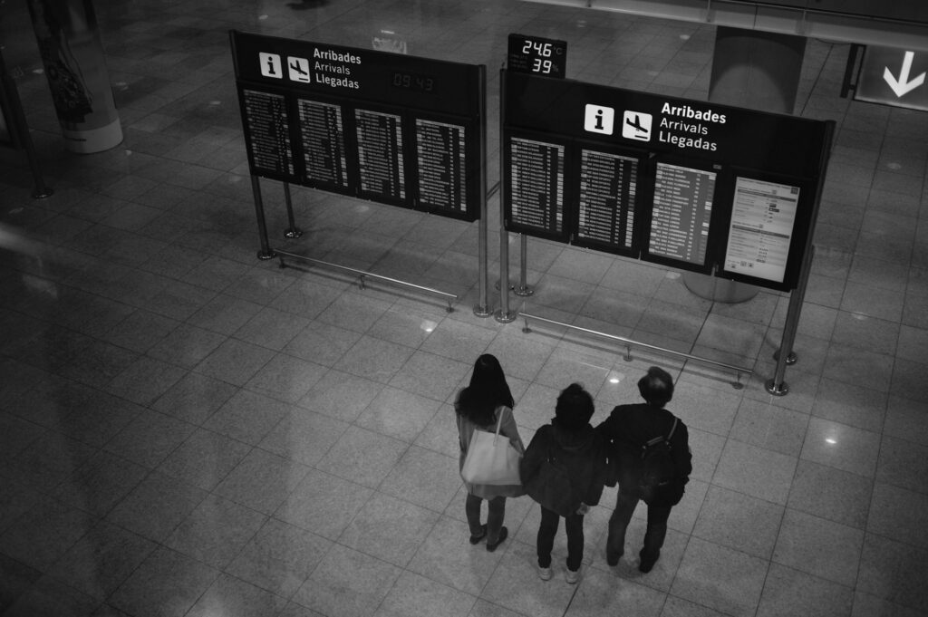 Voyageurs devant les panneaux Arribades et Arrivals de l'aéroport de Barcelone-El Prat