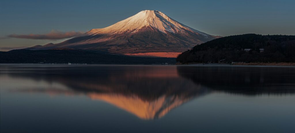 Mount Fuji reflected in a still lake at sunrise