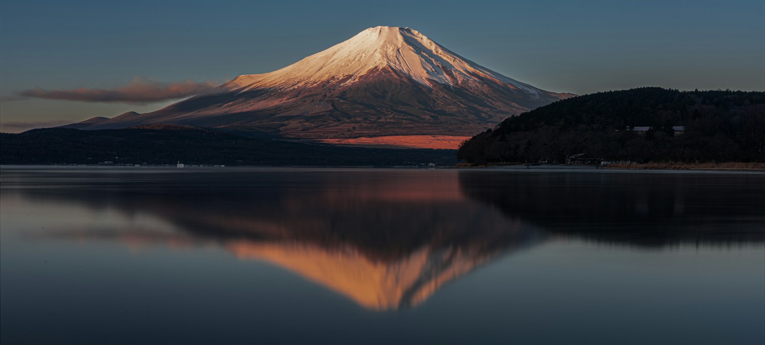 Mount Fuji reflected in a still lake at sunrise