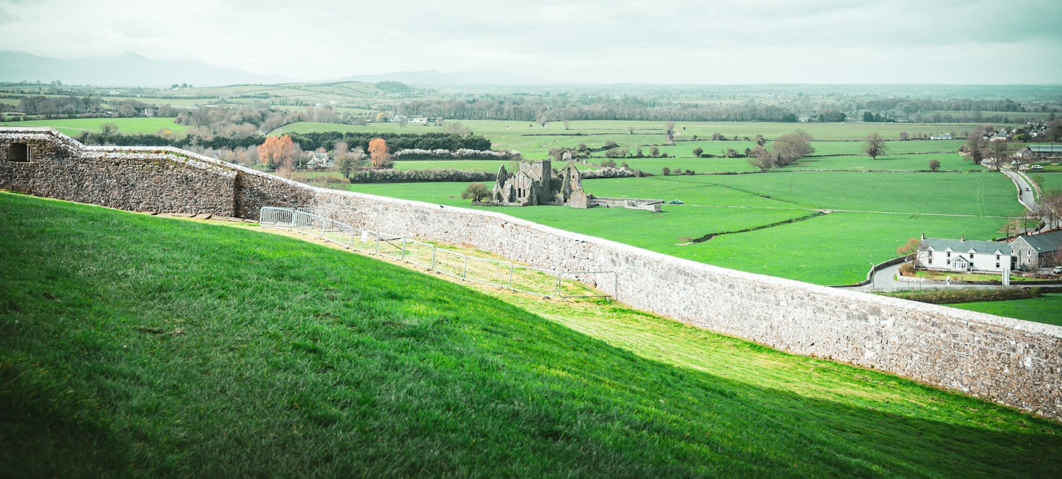 Stone wall running across green hills in the Irish countryside
