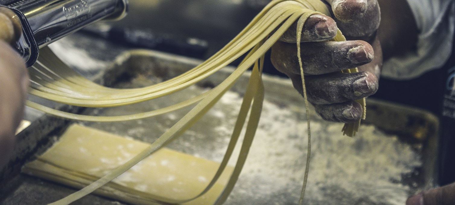 Fresh pasta spread out on a kitchen worktop