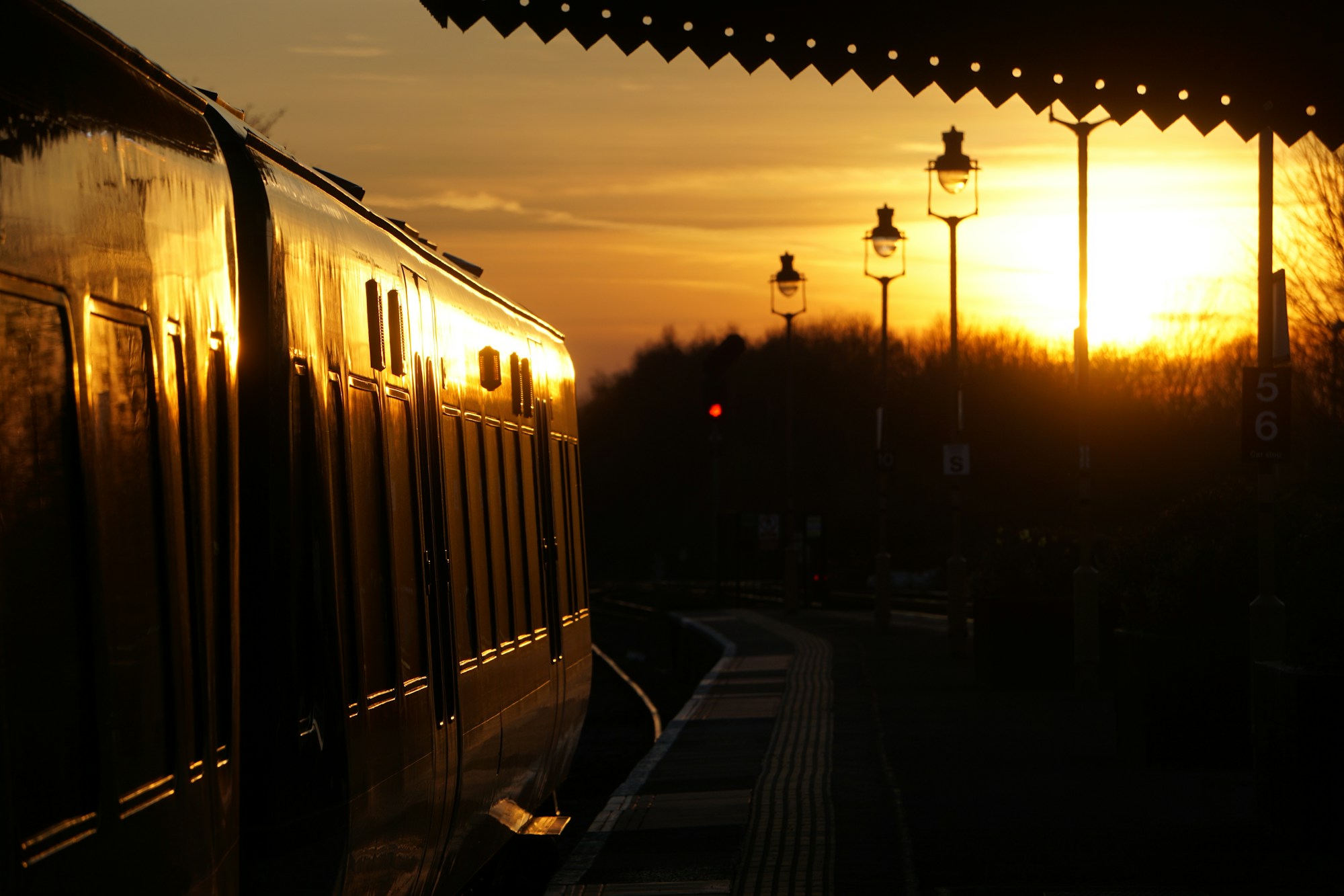 Quai d'une gare britannique presque vide au coucher du soleil