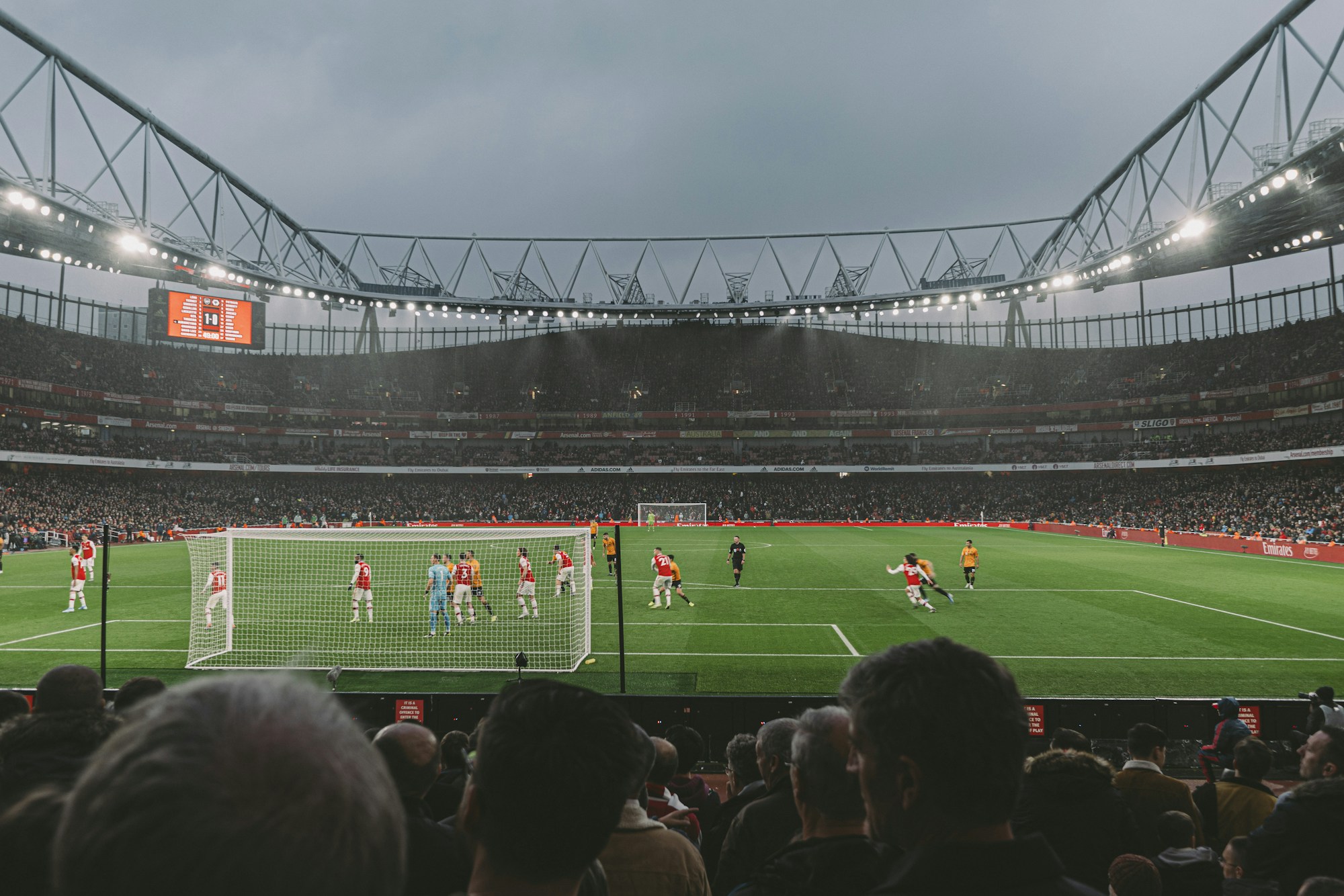 Tribunes d'un grand stade de football en fin de journée, pendant un match