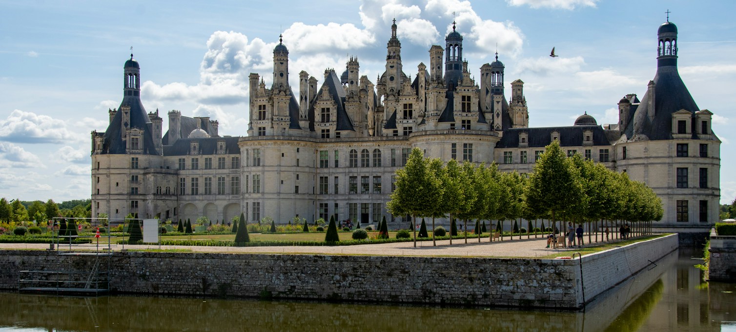 Loire Valley château, its facade and roofs reflected at the water's edge