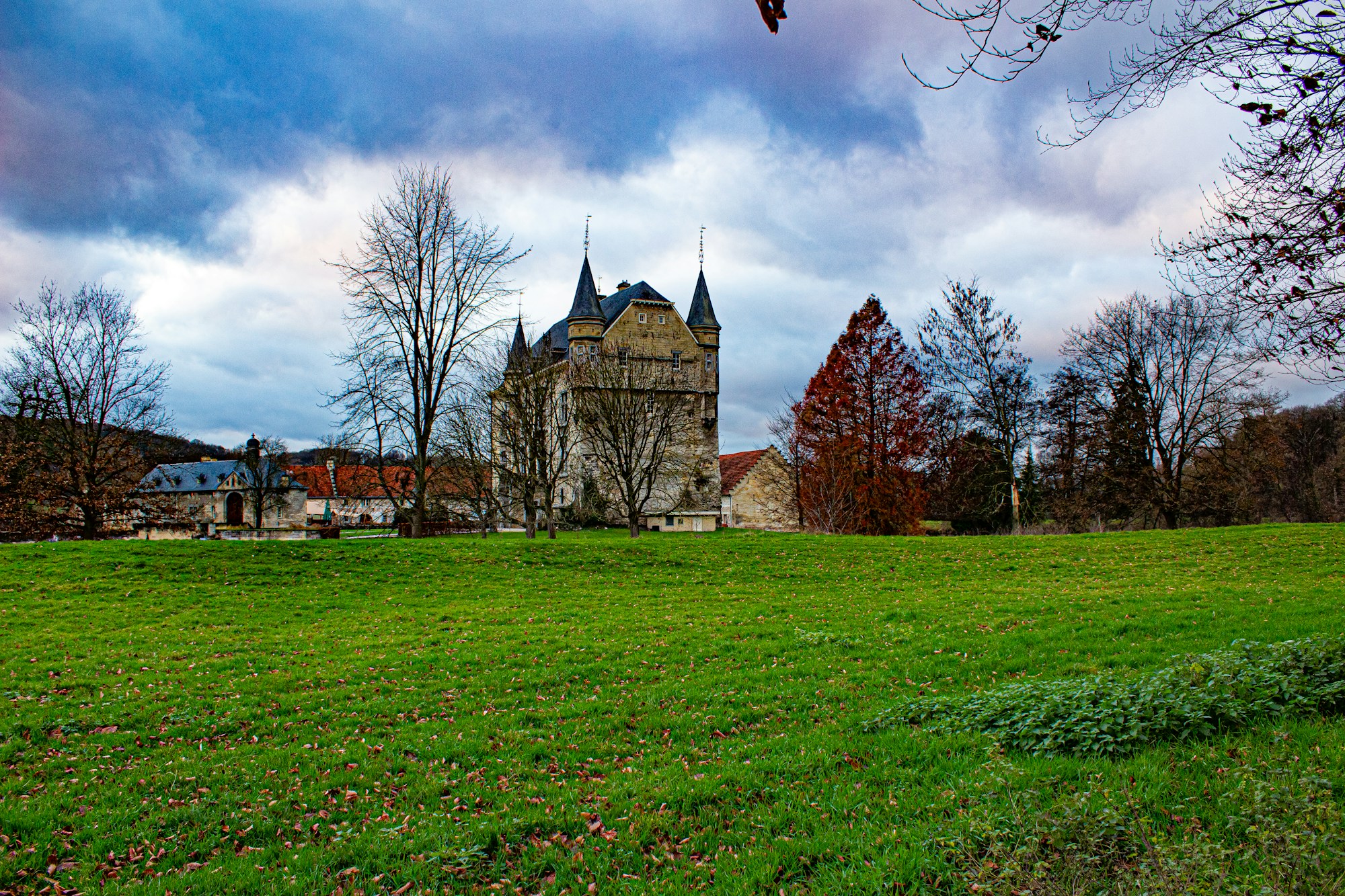 Burg Schaloen in Valkenburg aan de Geul, auf einer Wiese unter bedecktem Himmel