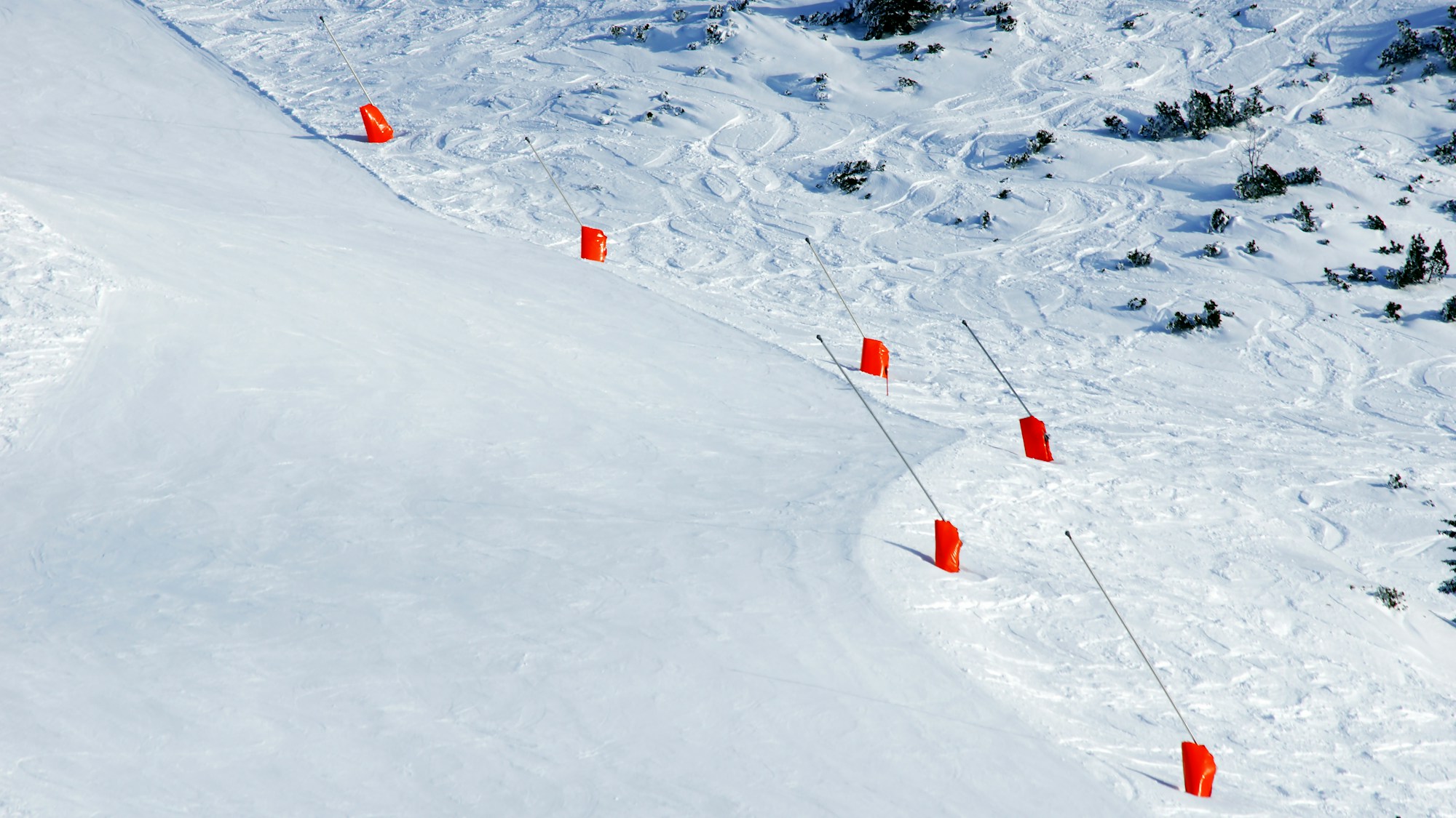Pista innevata segnata da paletti rossi da slalom