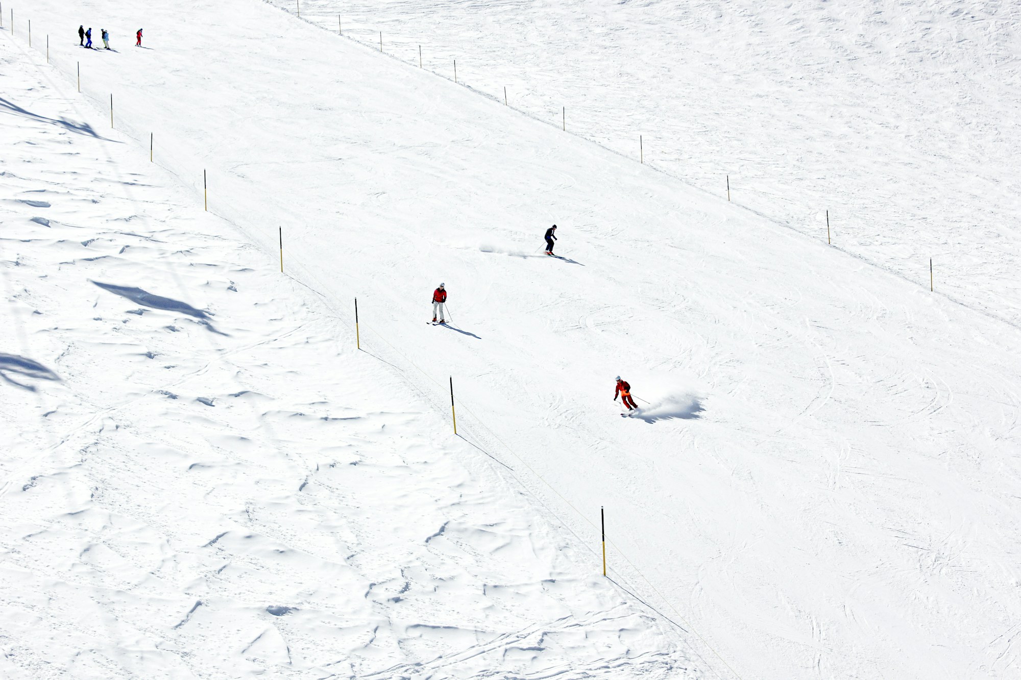 Sciatori su una grande pista innevata delimitata da paletti, in Svizzera