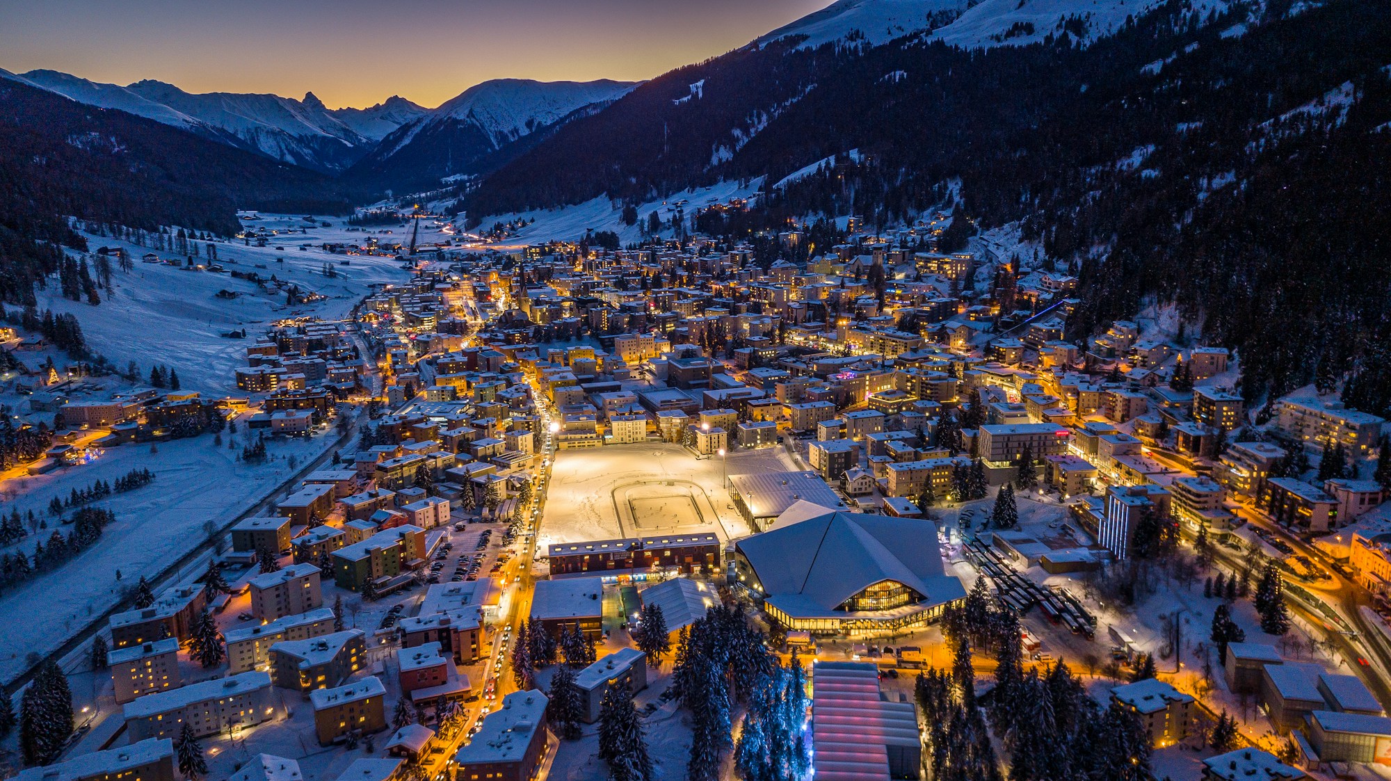 Aerial night view of Davos in winter, the rink and town-centre rooftops