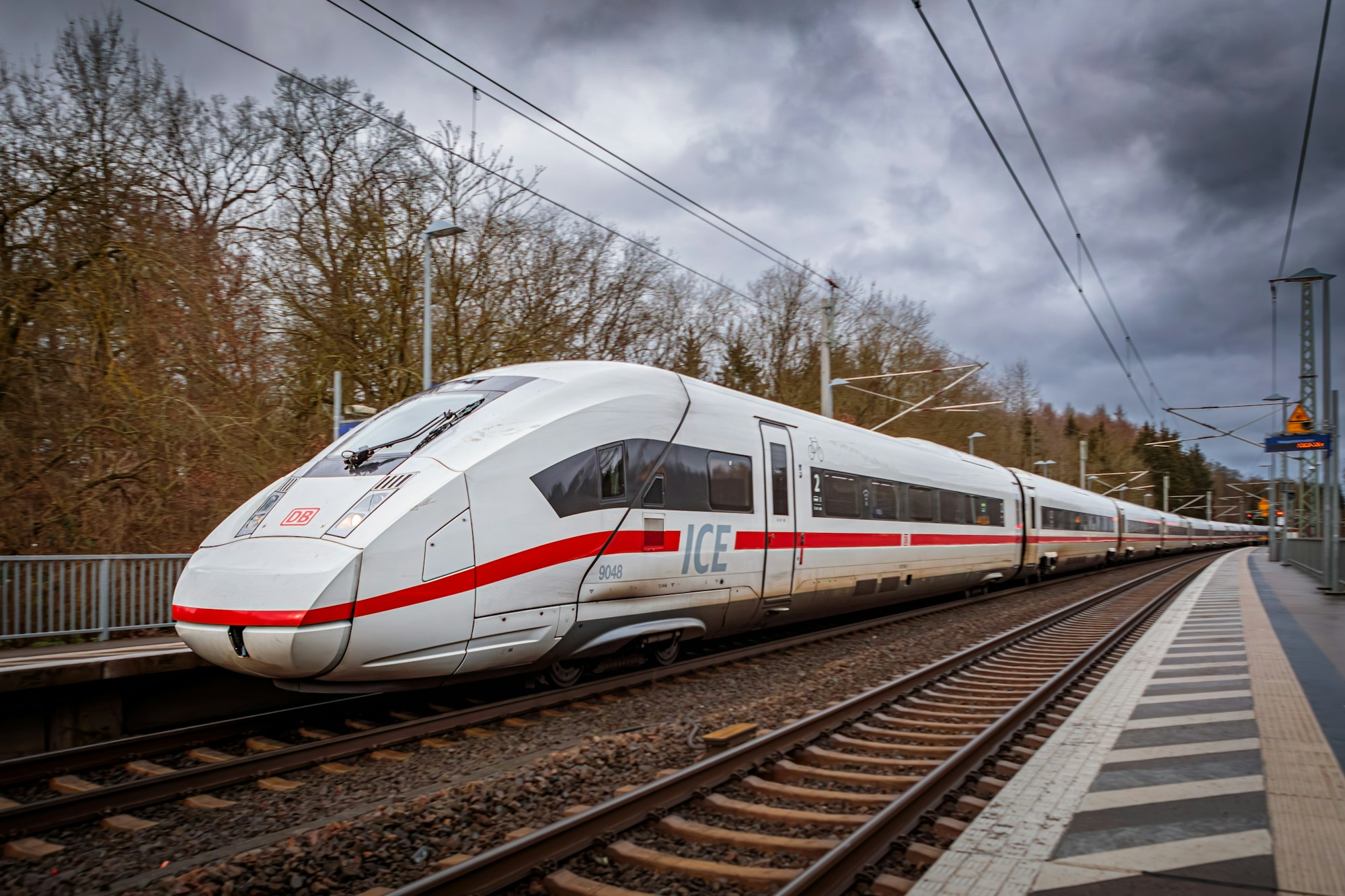 Train ICE qui passe à grande vitesse sous un ciel nuageux