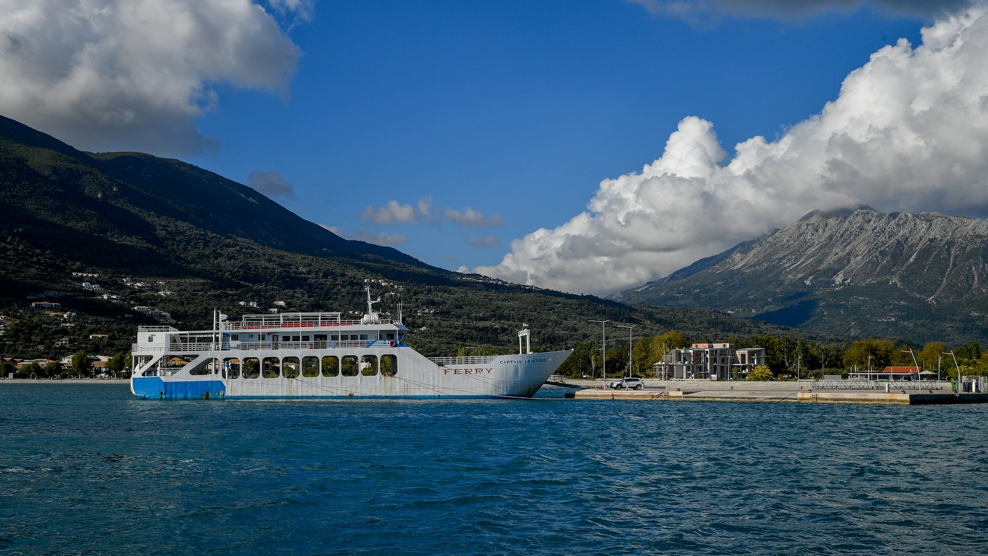 Ferry de passagers à quai sur la côte grecque, montagnes en arrière-plan