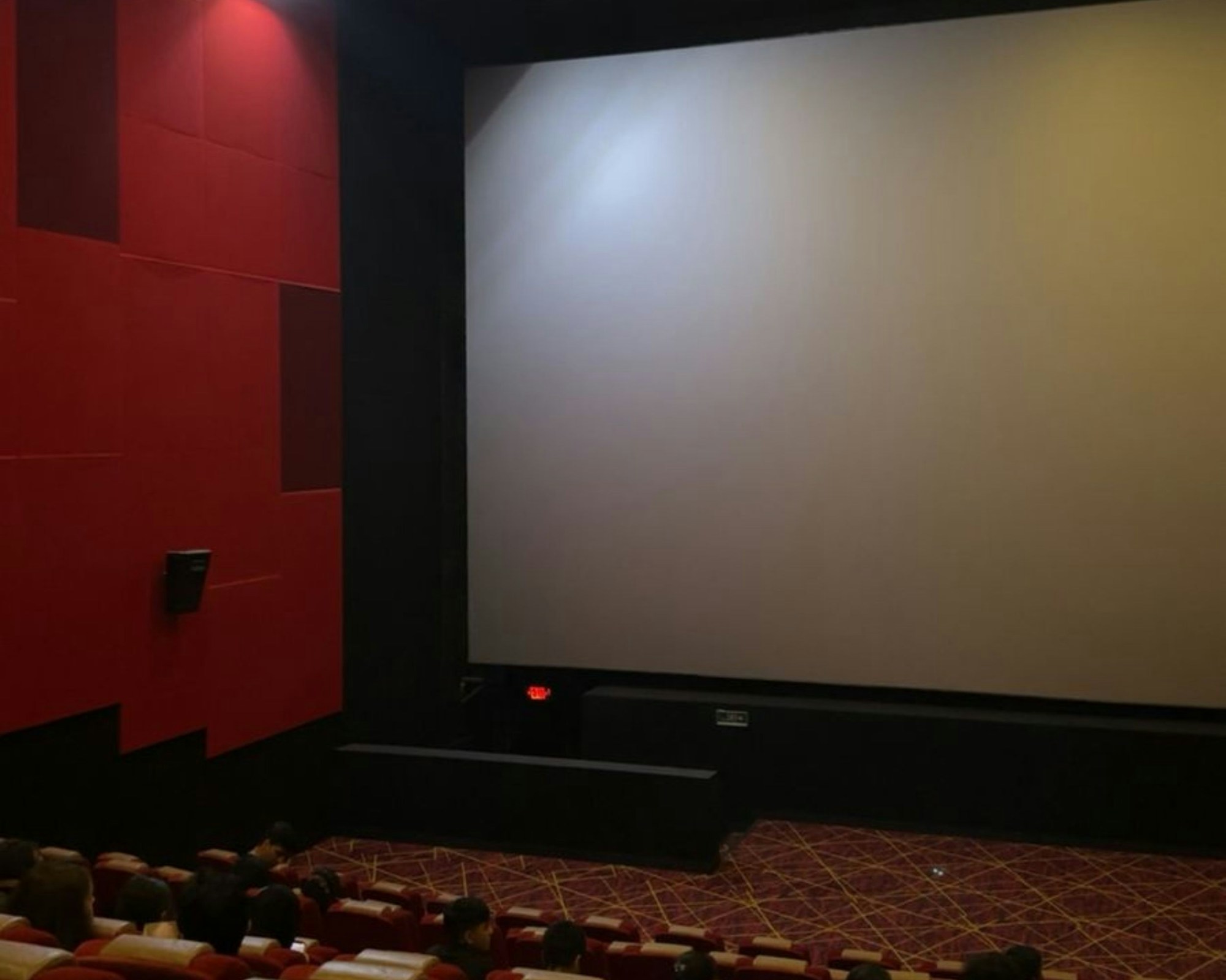 Eingangshalle eines modernen Kinos mit Theke und digitaler Anzeigetafel