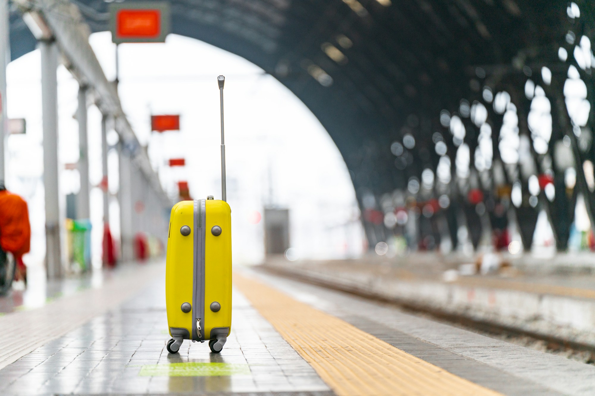 Gelber Koffer auf einem Bahnsteig des Bahnhofs Mailand Centrale