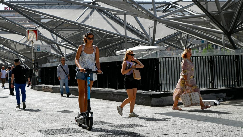 Piétons et trottinette sur la place Garibaldi à Naples