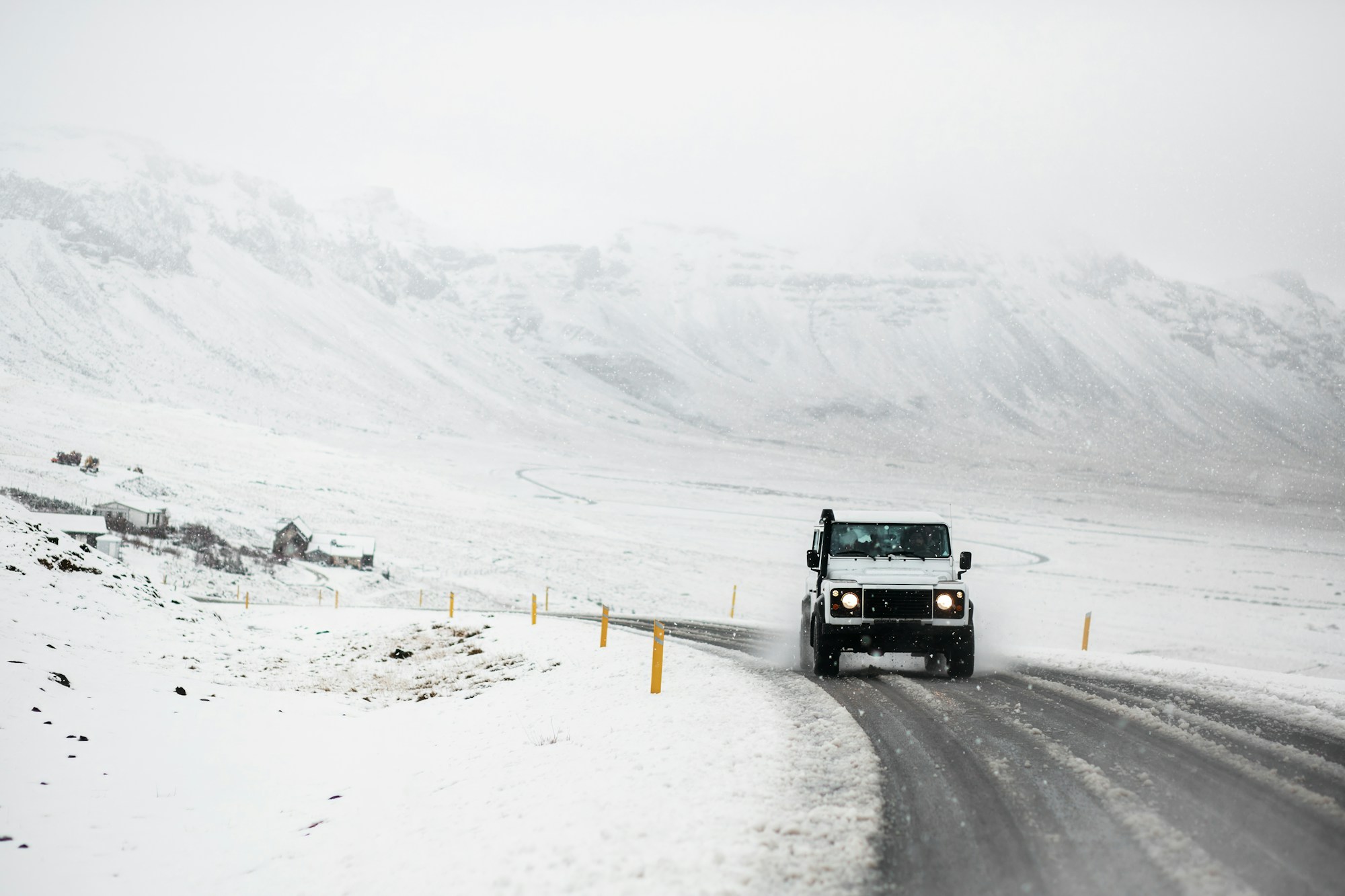 Allradfahrzeug auf einer verschneiten Straße im Westen Islands, im Winter