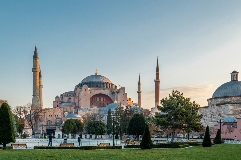 Hagia Sophia dome and minarets seen across Sultanahmet Square at sunset, Istanbul
