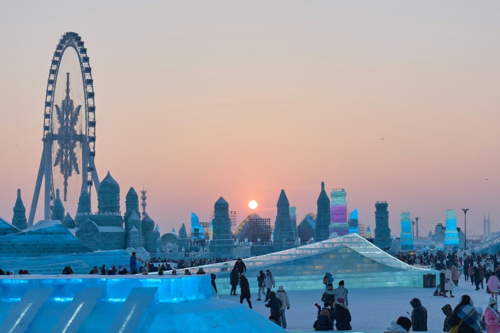 Visiteurs réunis devant une grande sculpture de glace, dans un festival d'hiver