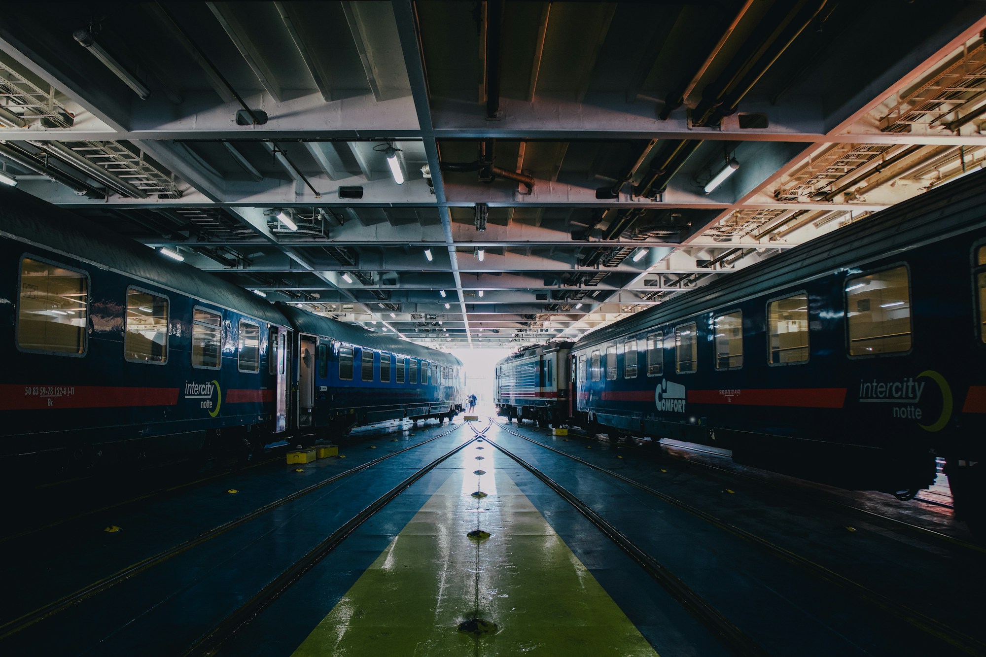 Blauer Nachtzug am Bahnsteig mit beleuchteten Fenstern in einem nächtlichen Bahnhof