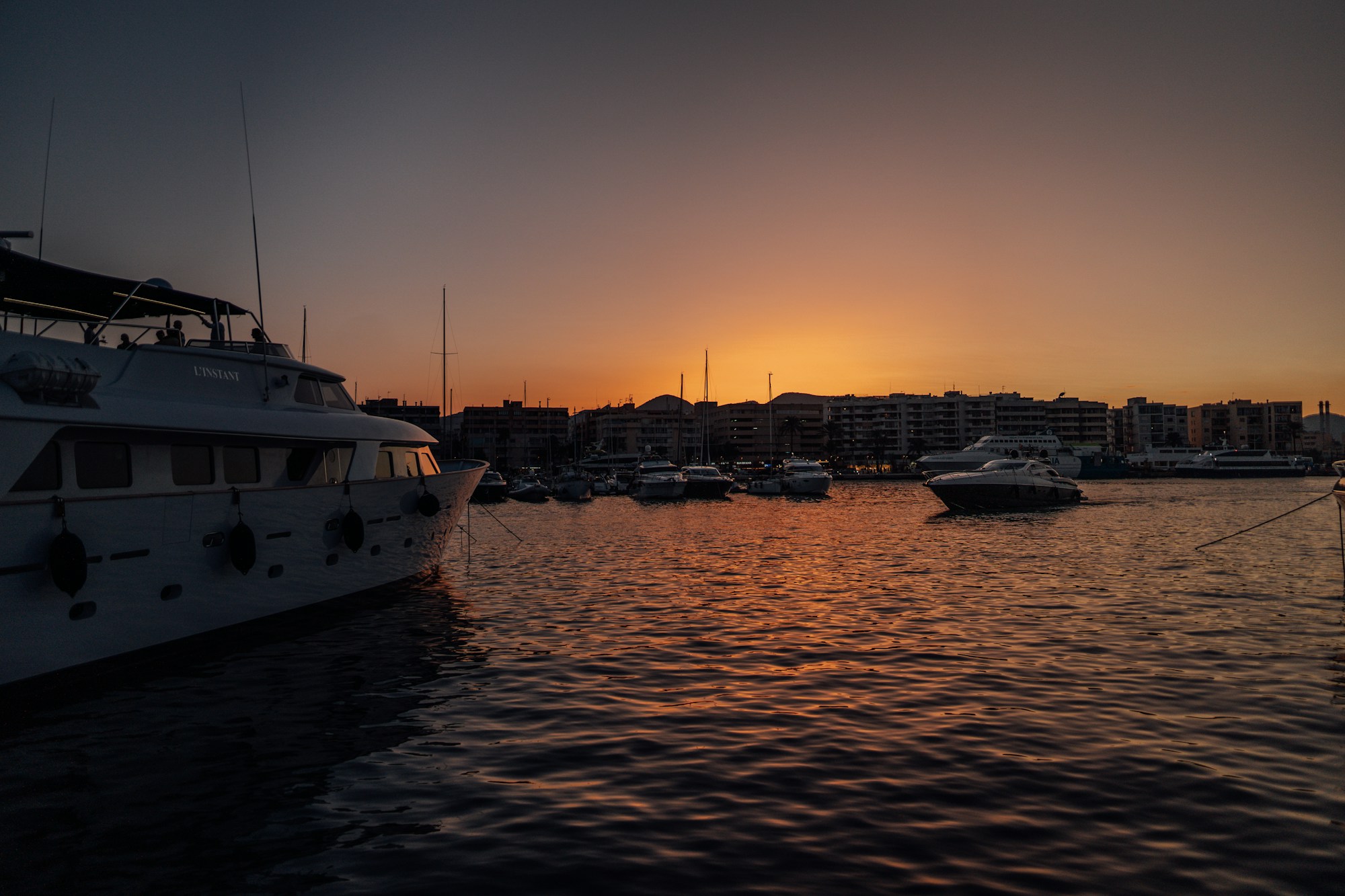 Ibiza harbour at dusk, boats moored facing the town