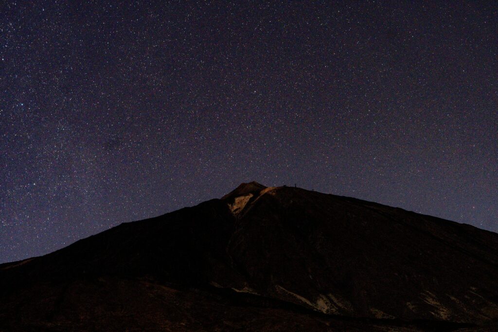 Ciel plein d'étoiles au-dessus d'une montagne sombre