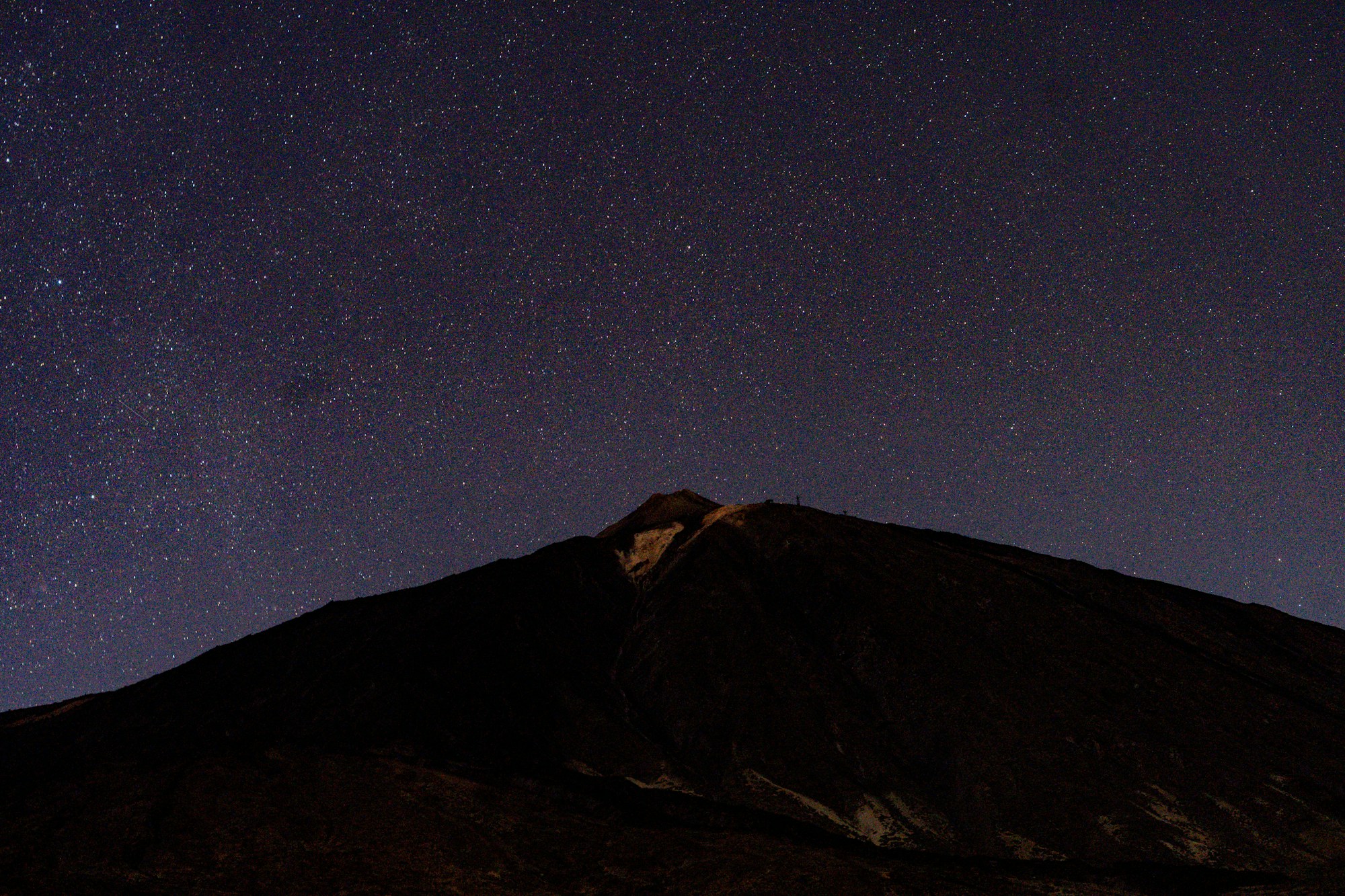 Sky full of stars above a dark mountain