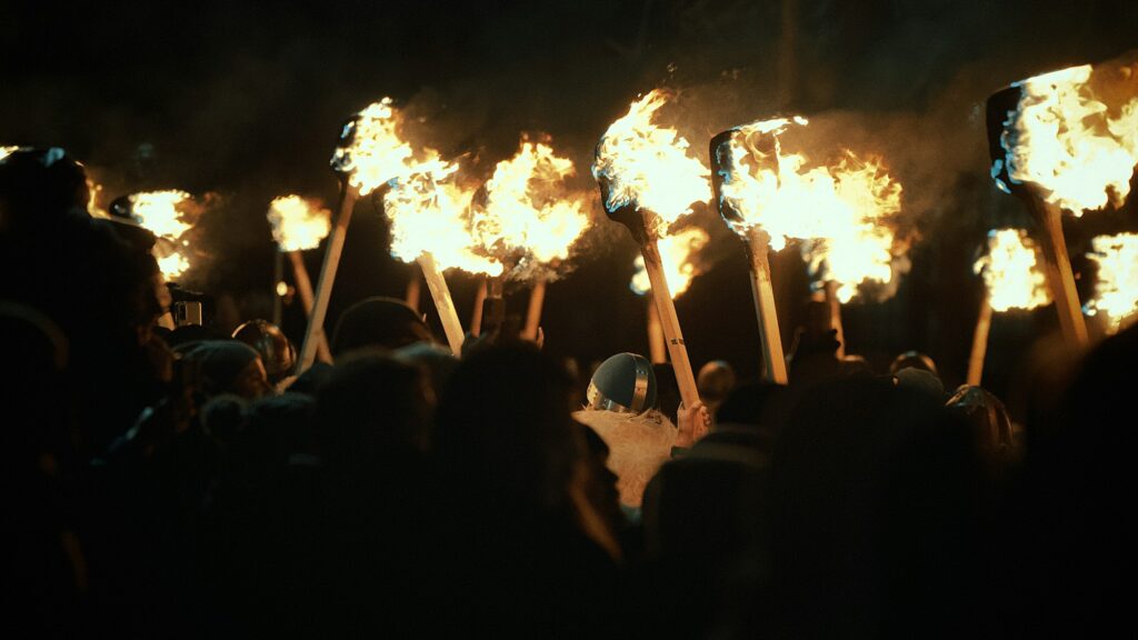 Foule tenant des torches enflammées dans la nuit, ambiance de procession de Bonfire Night