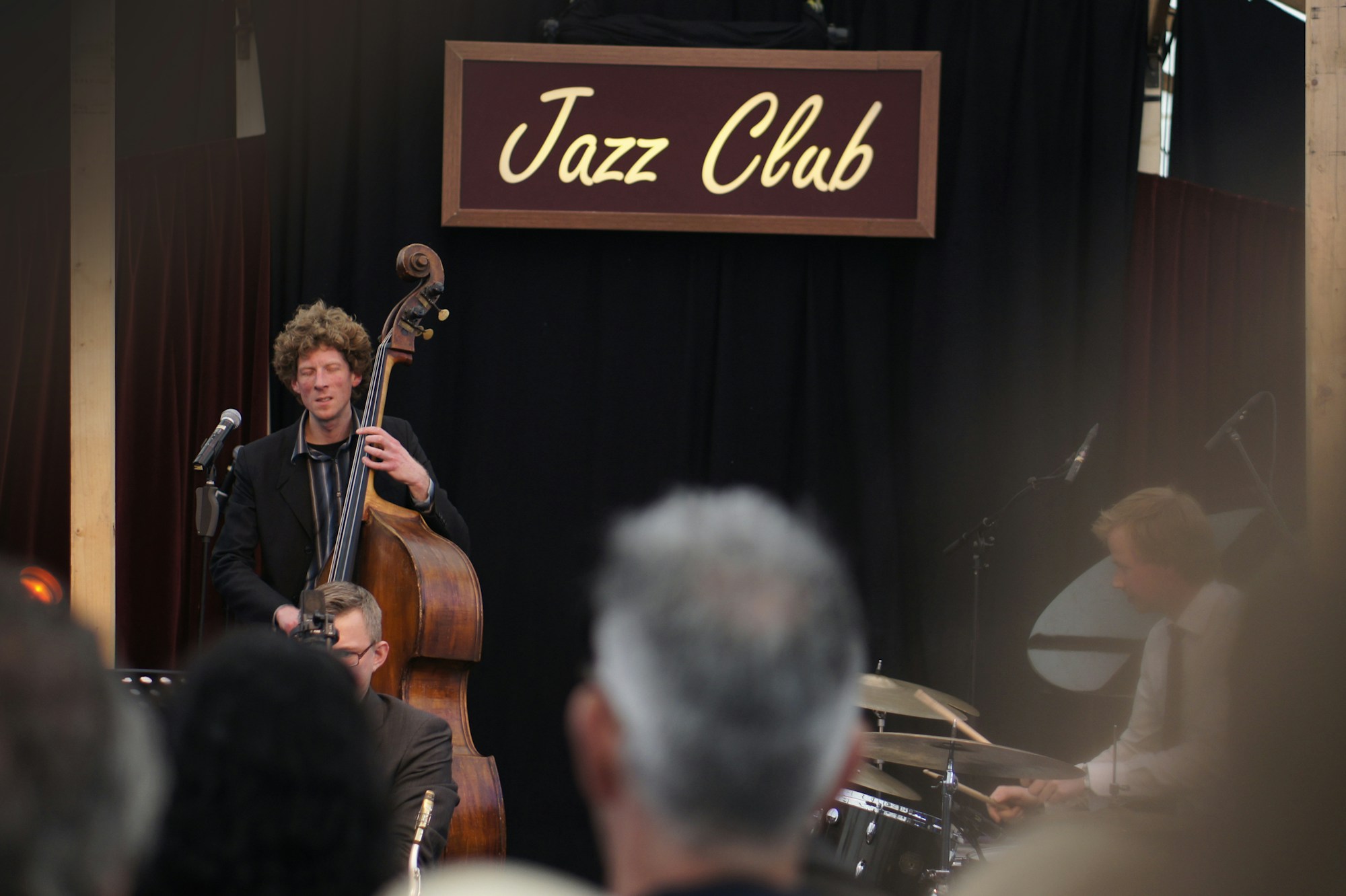 Petit club de jazz avec des musiciens sur scène et un public très proche