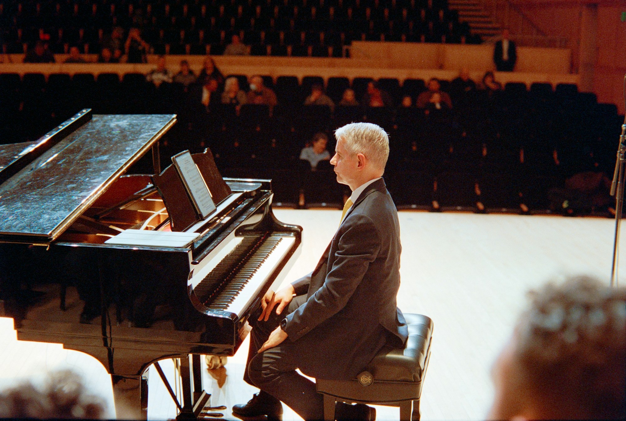 Pianiste en concert dans une grande salle de spectacle, lumière chaude