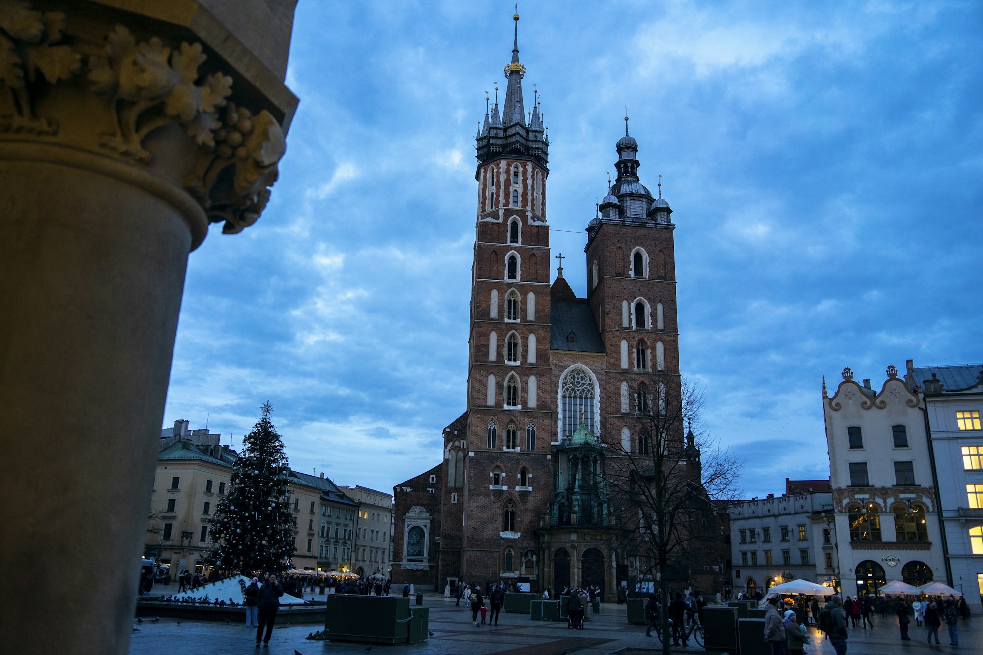 Mercado de Navidad en el Rynek Główny de Cracovia al anochecer, con la basílica de Santa María