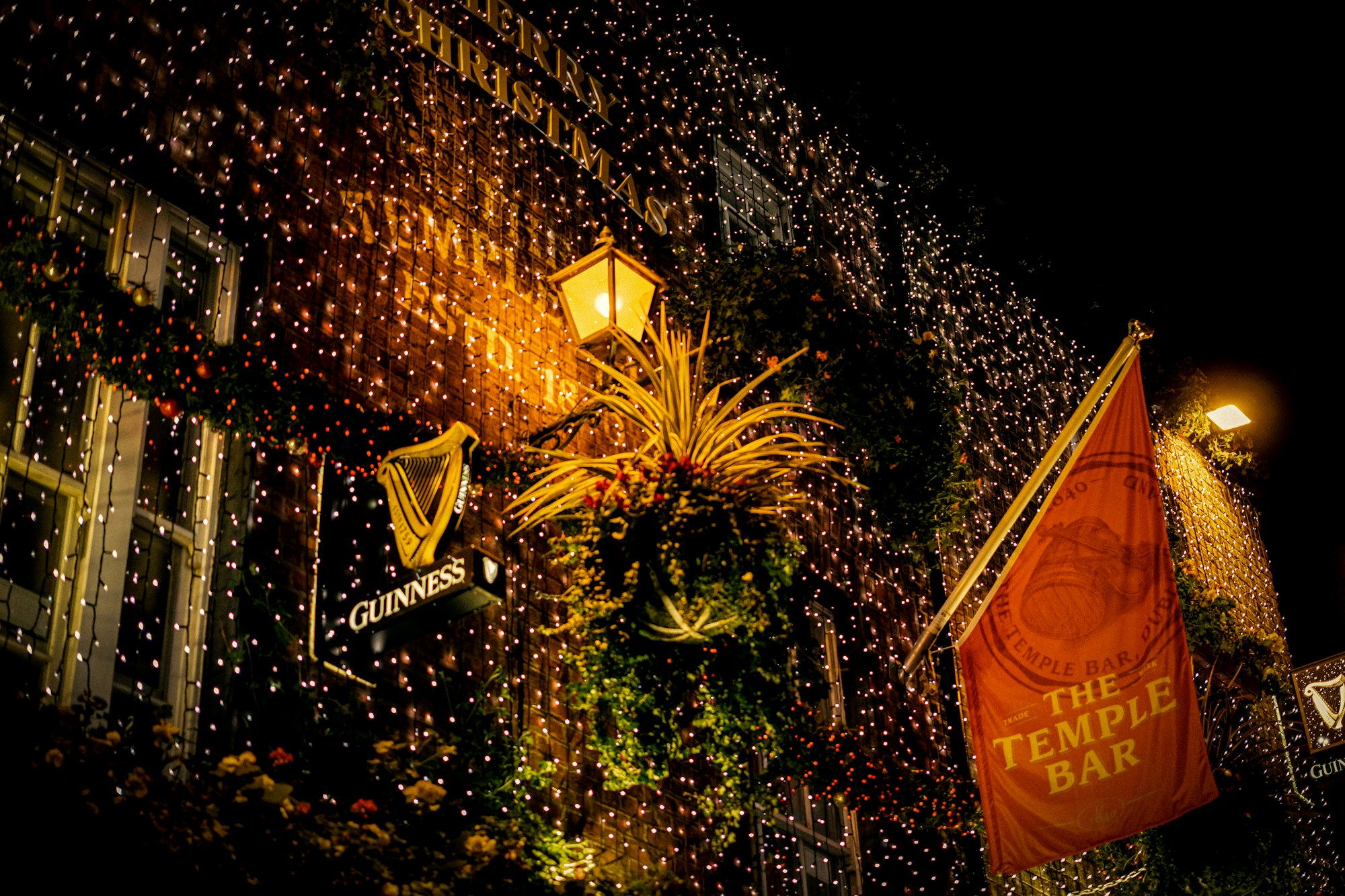 Fachada de un pub de Temple Bar decorada con guirlandas luminosas, de noche