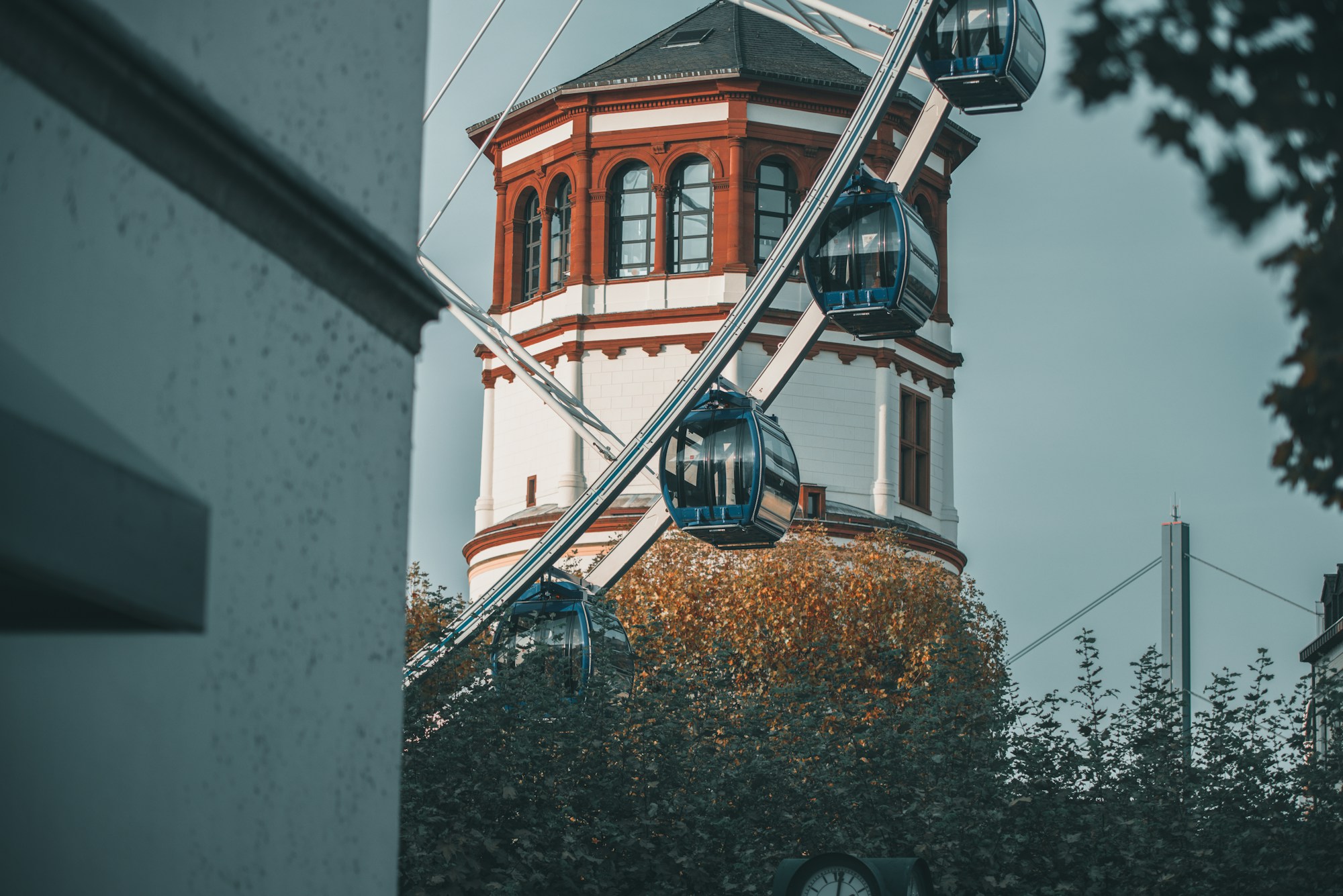 Blue-gondola Ferris wheel in front of a brick tower in Düsseldorf