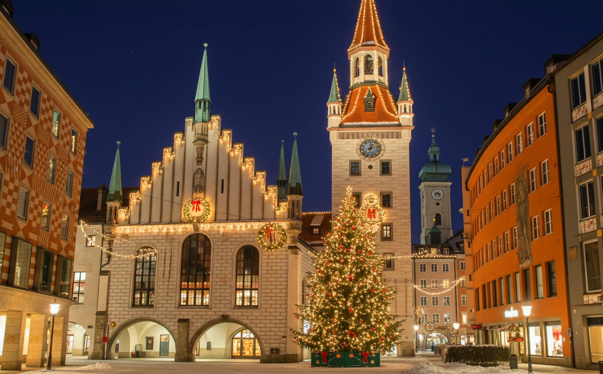 Hôtel de ville de Munich aux façades gothiques et sapin de Noël illuminé sur la place Marienplatz à la tombée de la nuit