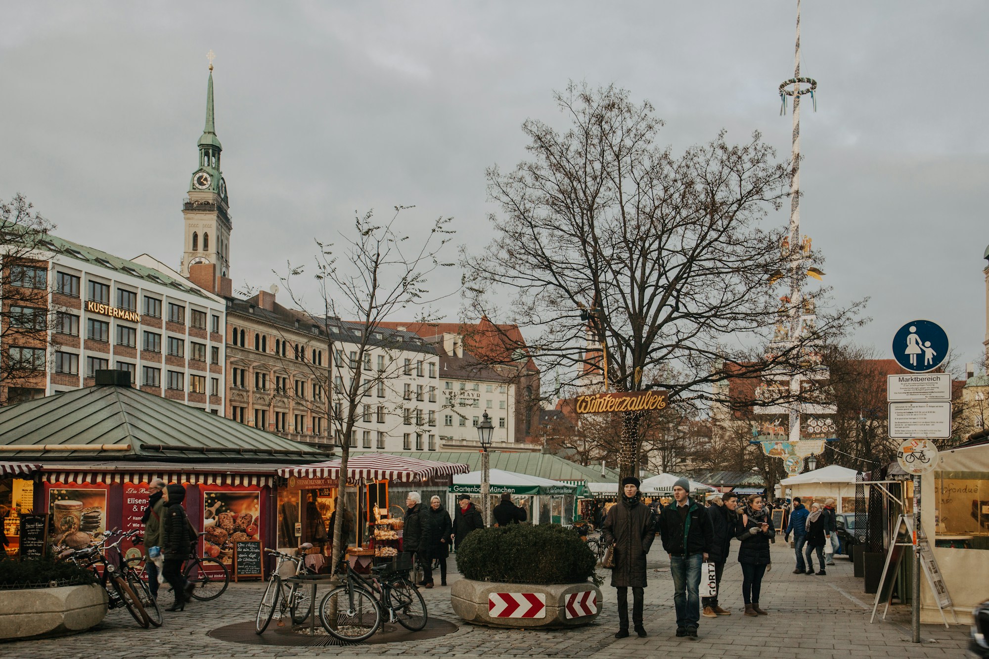 Place du centre de Munich en fin de journée d'hiver, avec un grand mât de fête et des étals de saison