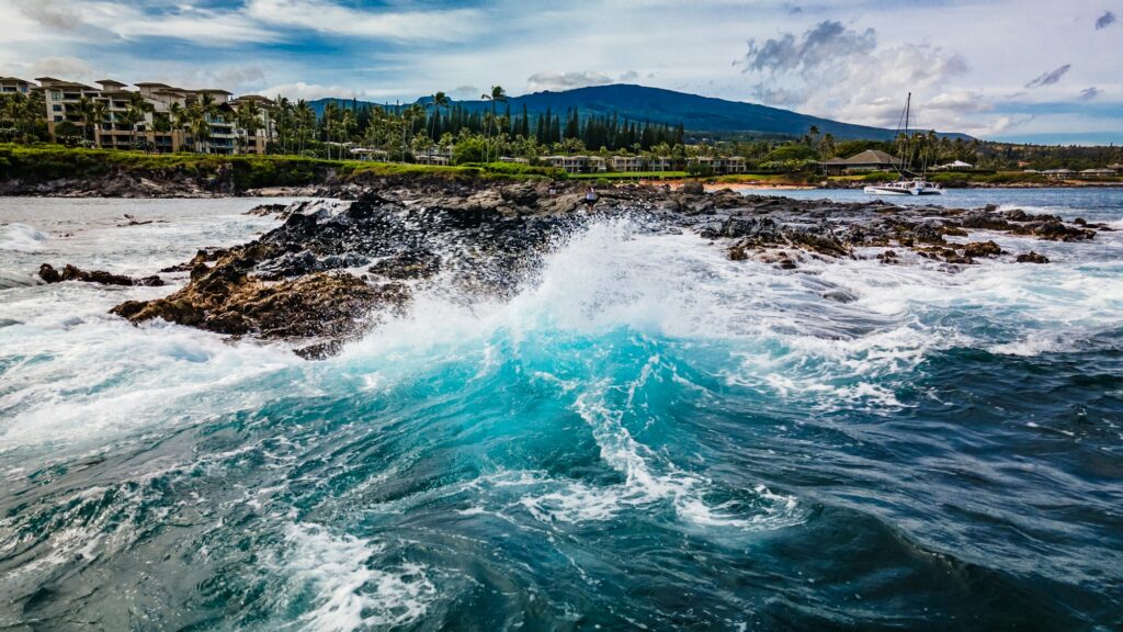 Vagues turquoise qui se brisent sur les rochers volcaniques de la côte de Maui