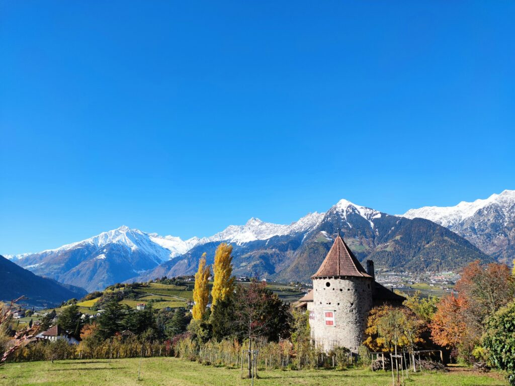 Château à toit pointu dans les prés de Merano, Alpes enneigées en arrière-plan