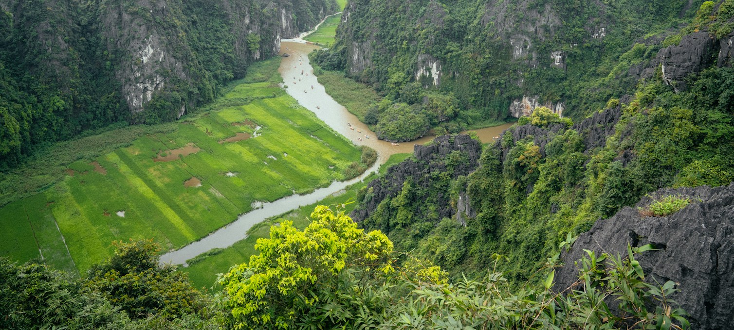 Pitons de calcaire au-dessus de rizières et d'une rivière à Ninh Bình