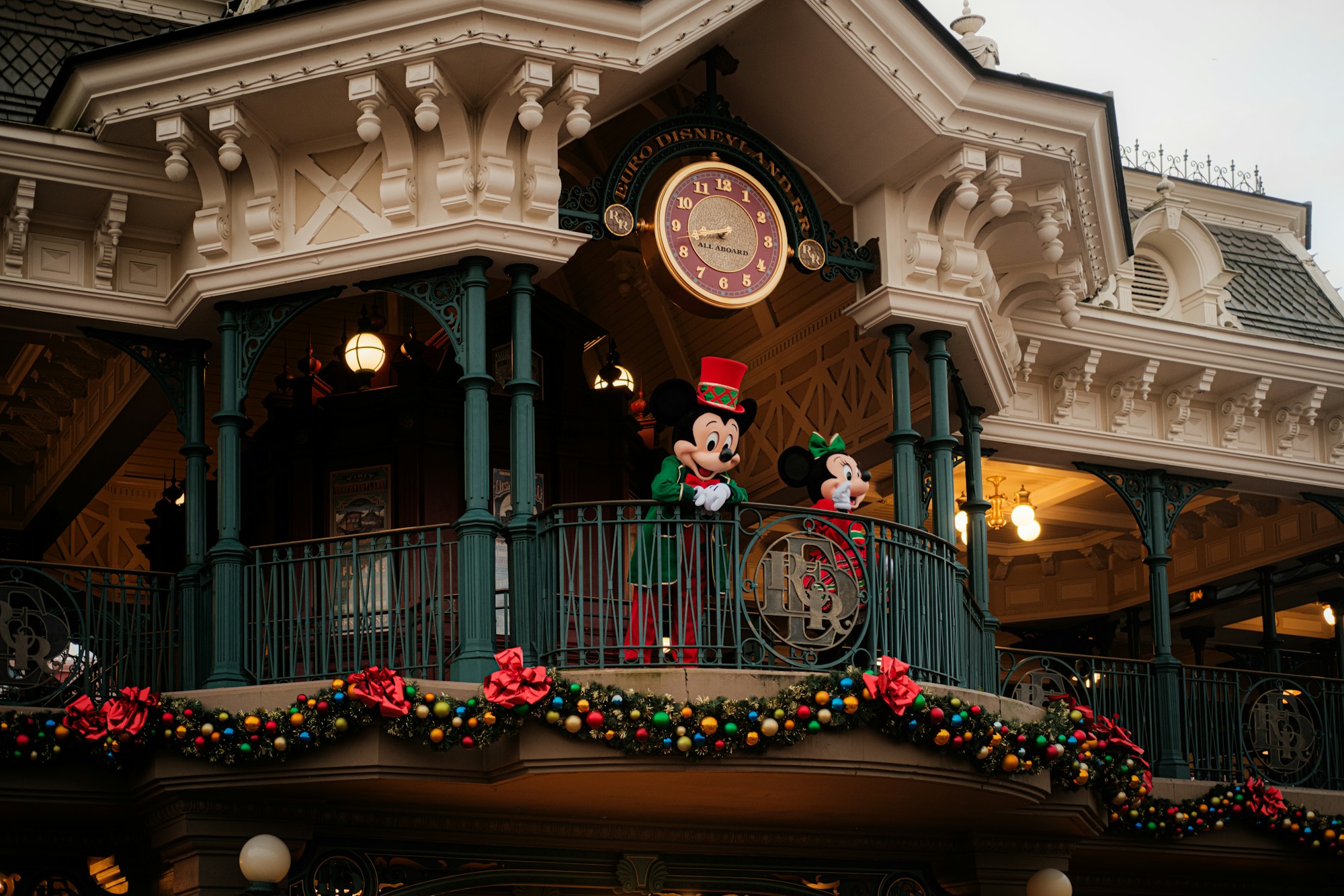 Fachada de Main Street, U.S.A. en Disneyland Paris, con guirnaldas navideñas y Mickey y Minnie vestidos de fiesta