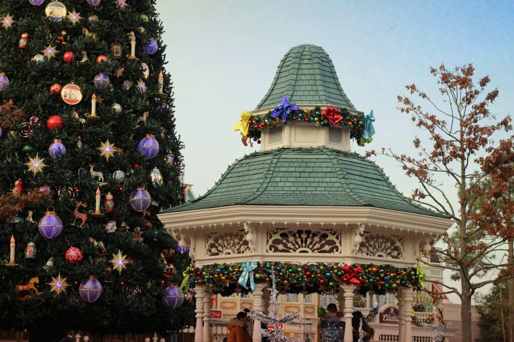 Sapin de Noël et kiosque décorés de guirlandes à Disneyland Paris