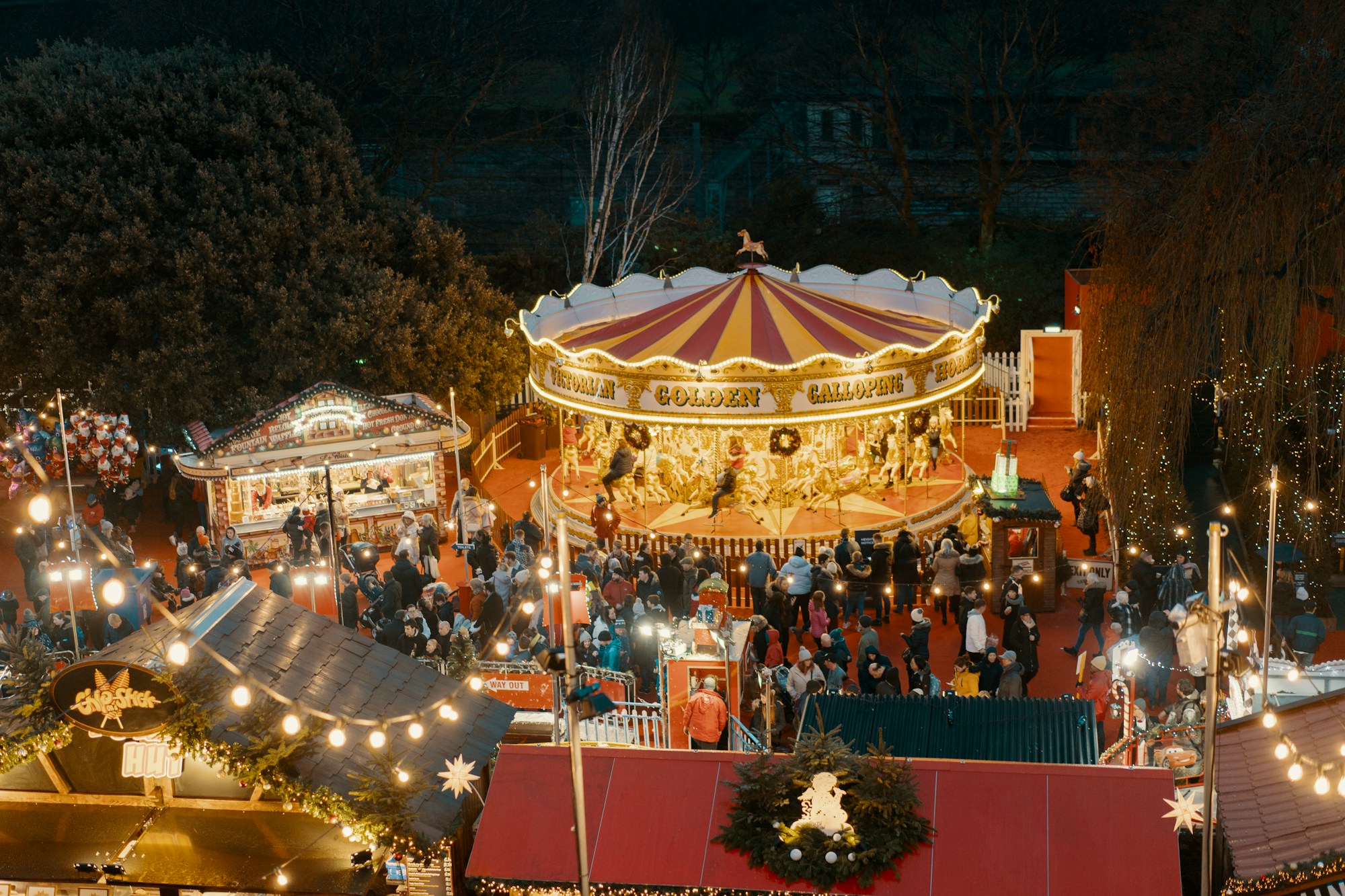 Weihnachtsmarkt in Edinburgh bei Nacht, mit Chalets und Lichterketten