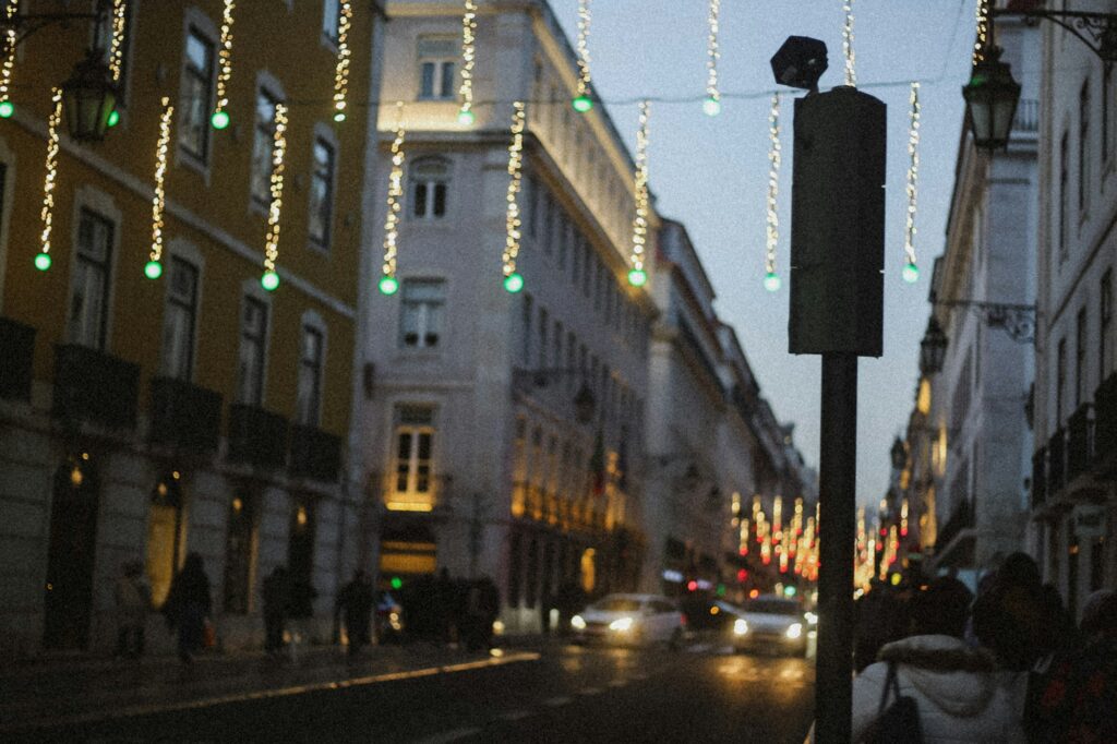Rue du centre historique de Lisbonne illuminée de guirlandes lumineuses à la tombée de la nuit