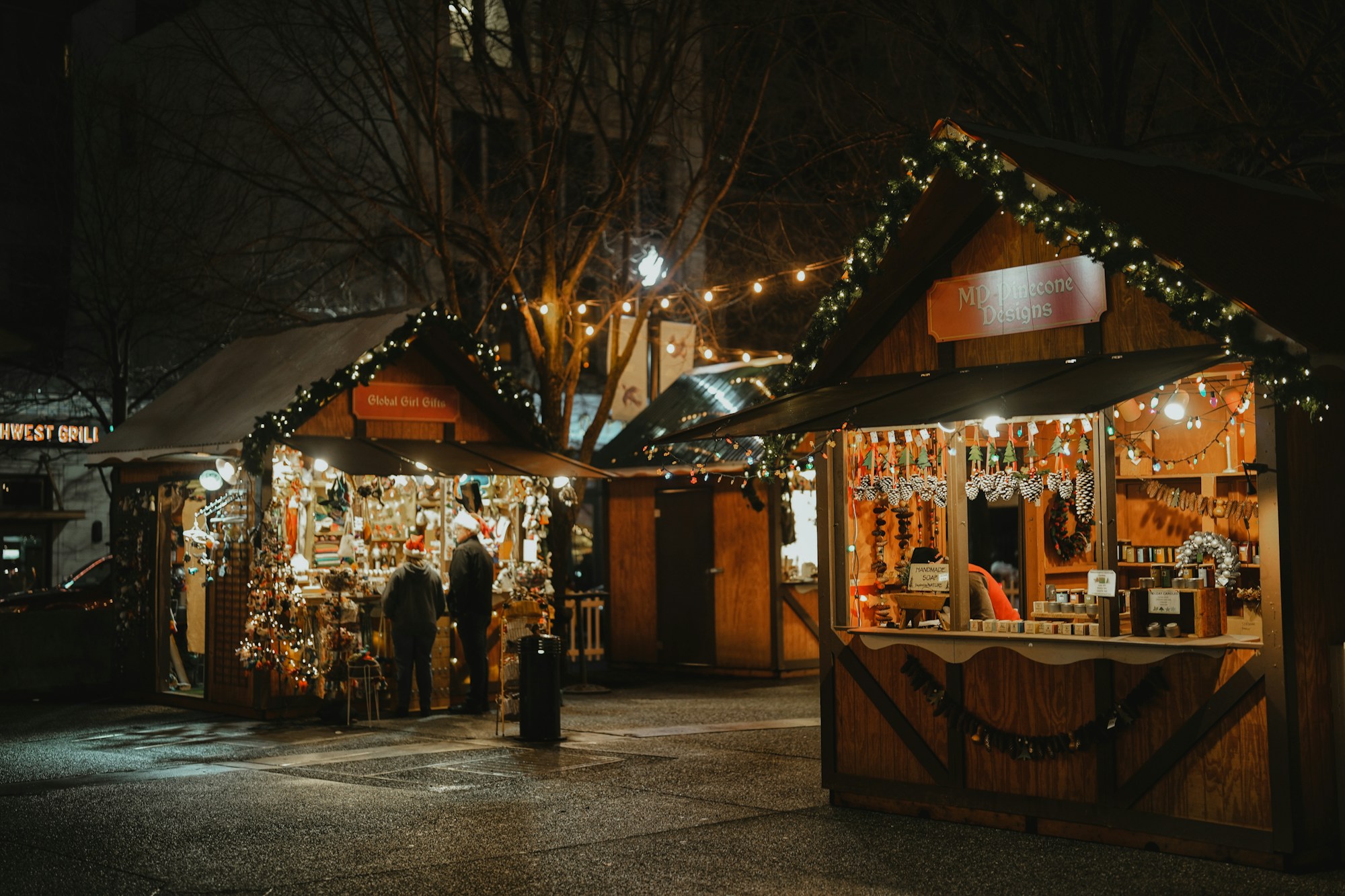 Illuminated wooden chalets at a Christmas market at dusk