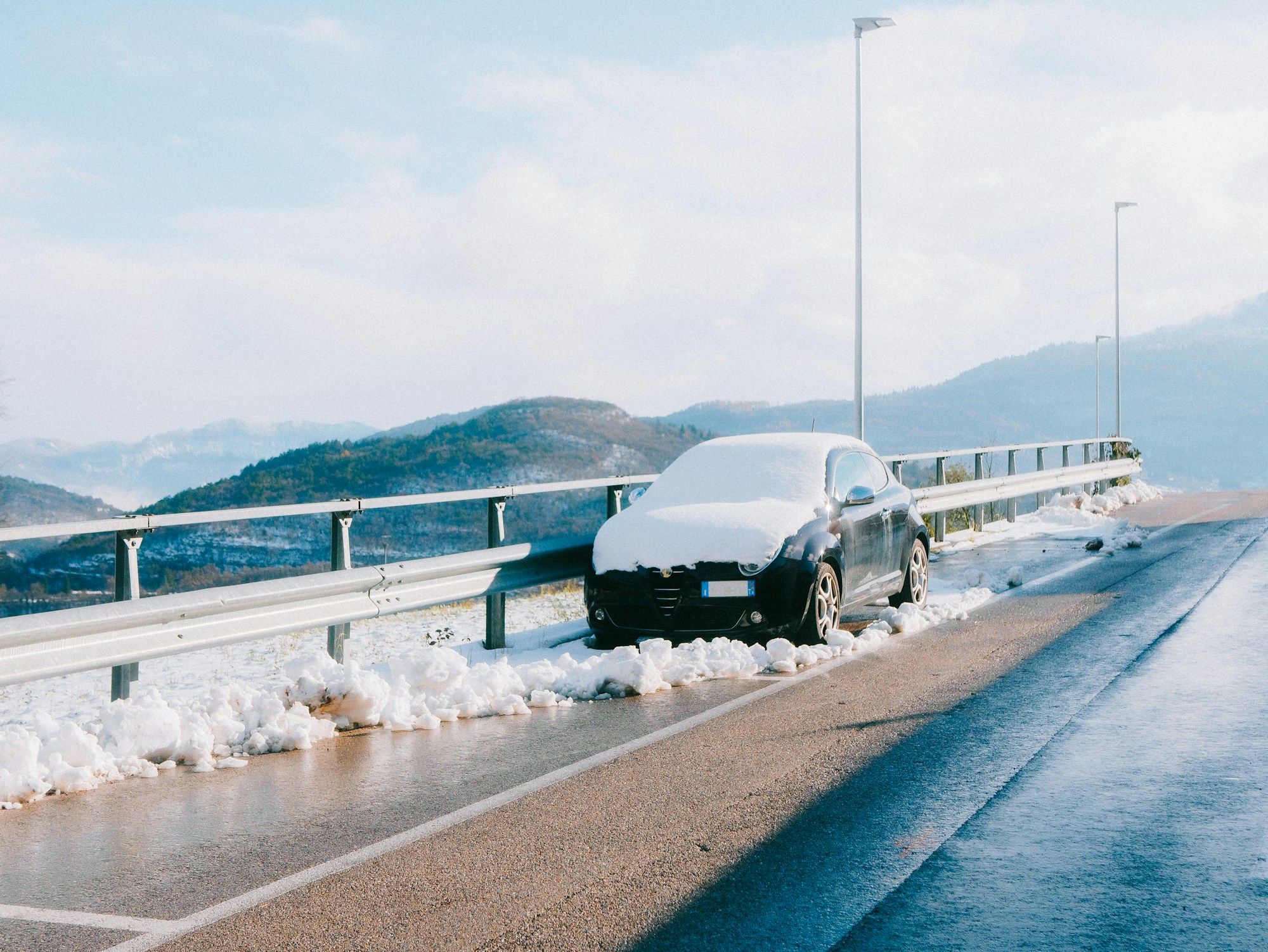 Auto unter Schnee auf einer Winterstraße