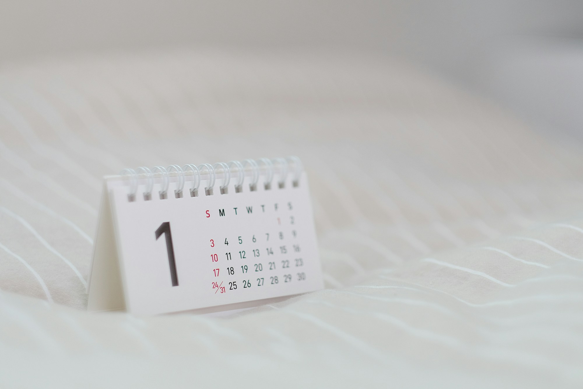 Calendario bianco appoggiato su un tessuto chiaro