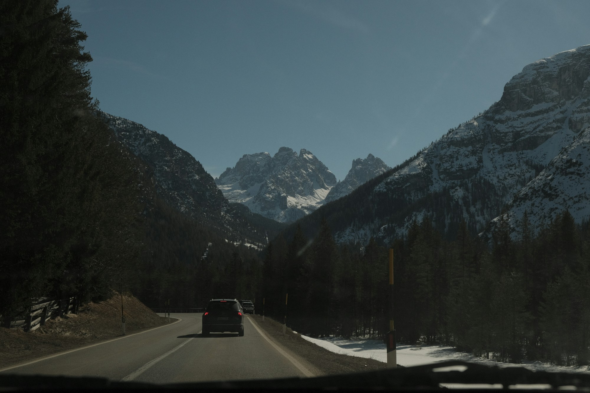 Verschneite Bergstraße, die in ein alpines Tal hinabführt