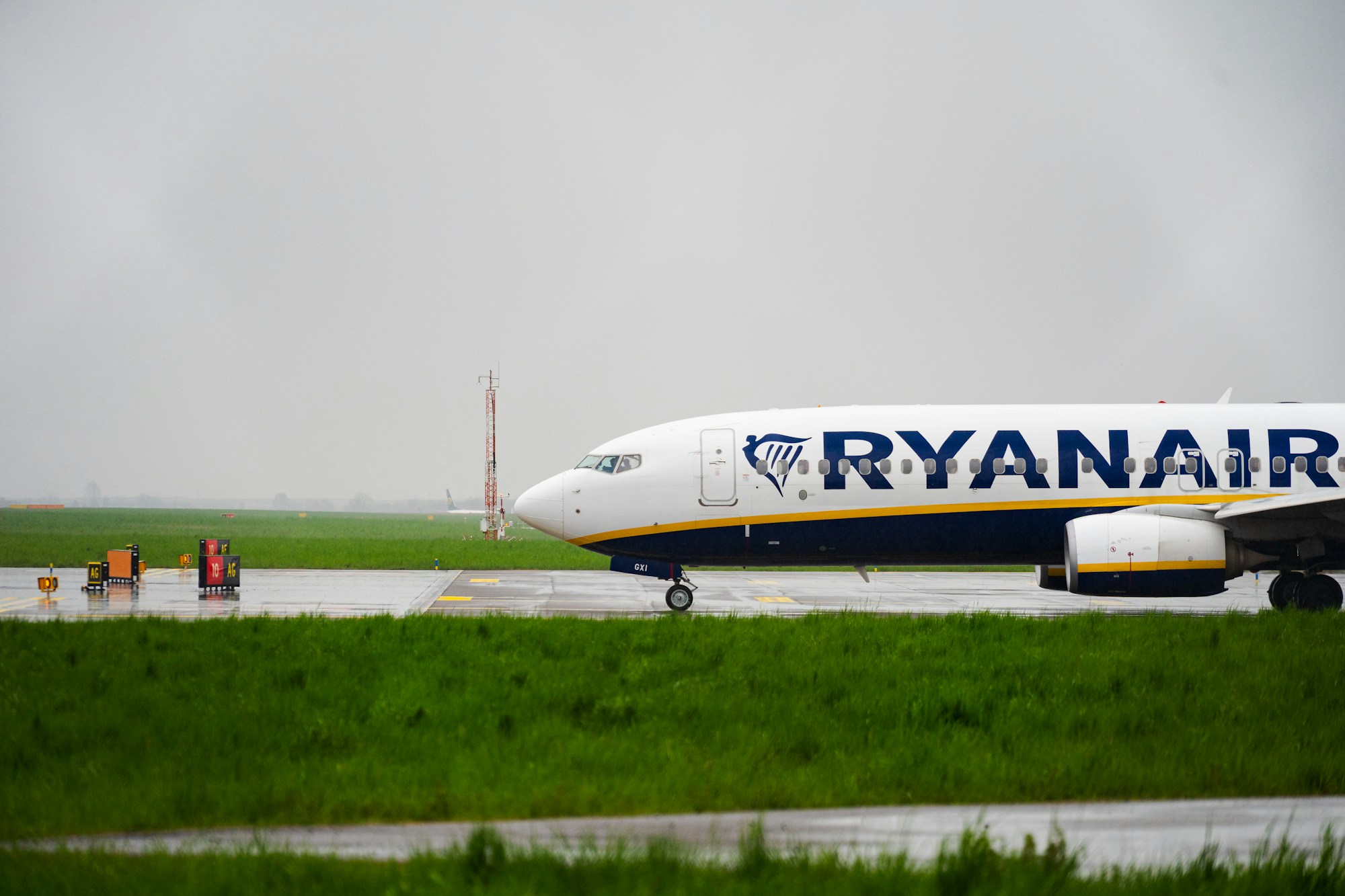 Ryanair-Flugzeug auf einem nassen Vorfeld bei Regen