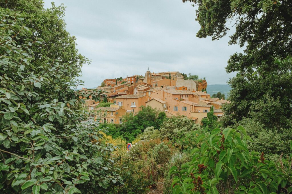 Village perché de Provence aux façades ocre, sous un ciel nuageux