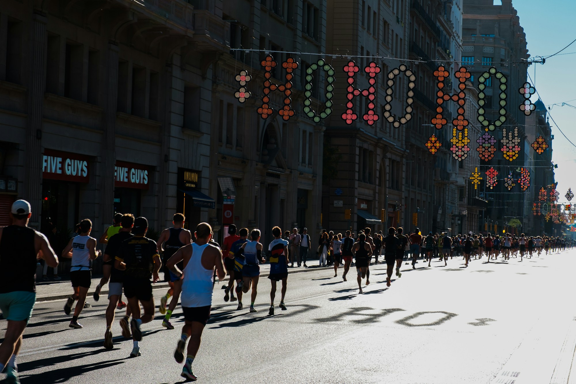 Coureurs sur une avenue décorée de lumières pendant une course populaire